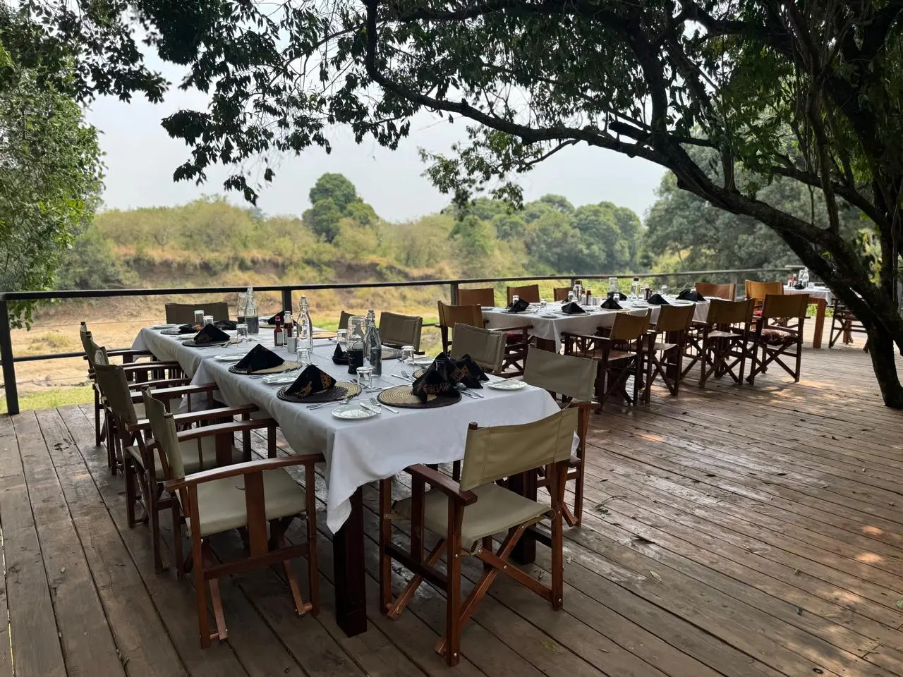 Full group dining table under the trees at Enkakenya — long outdoor setting