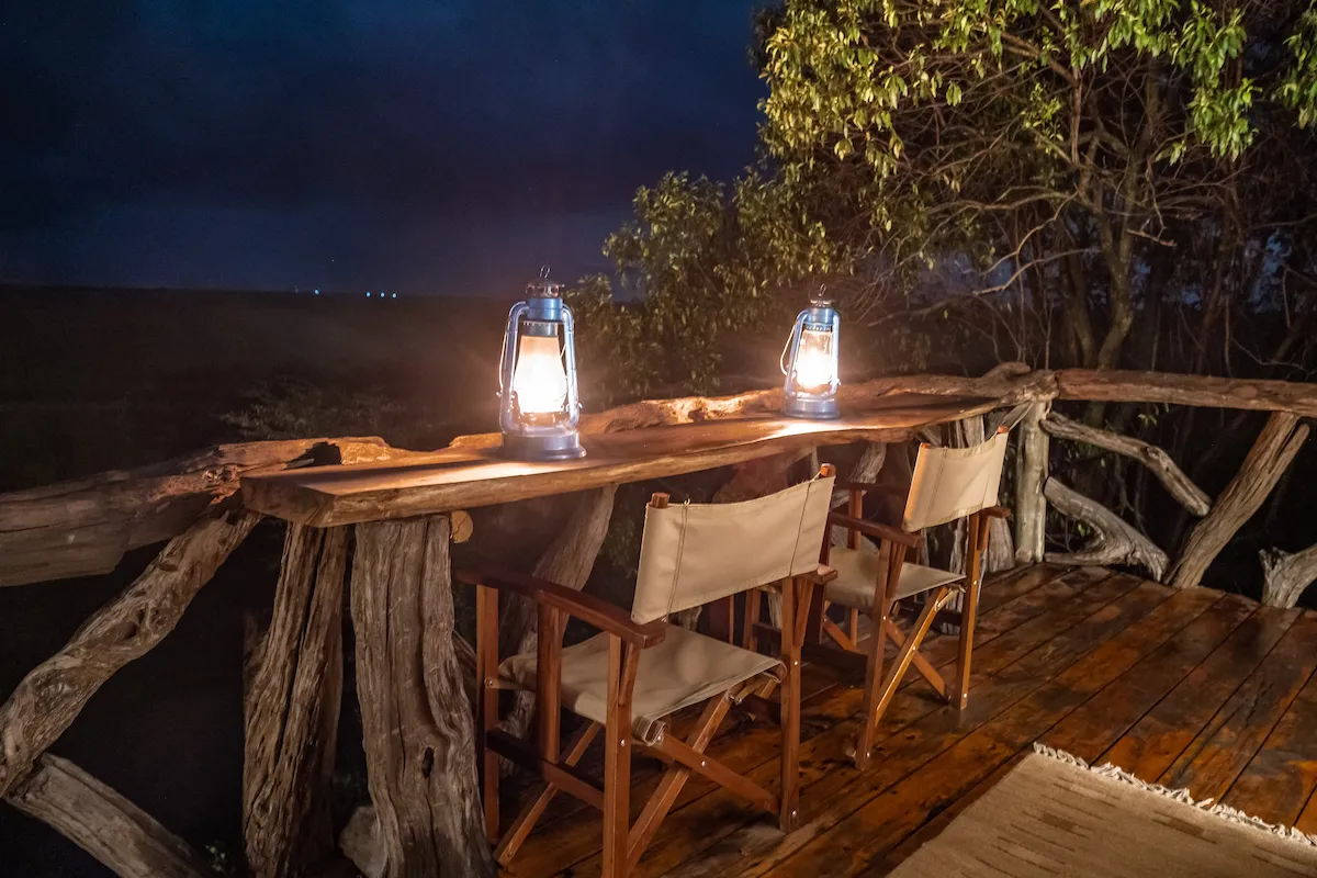 Two lanterns on the Starbed driftwood rail at dusk