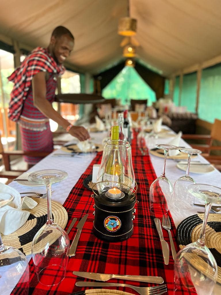 Masai warrior setting up table at Enkakenya