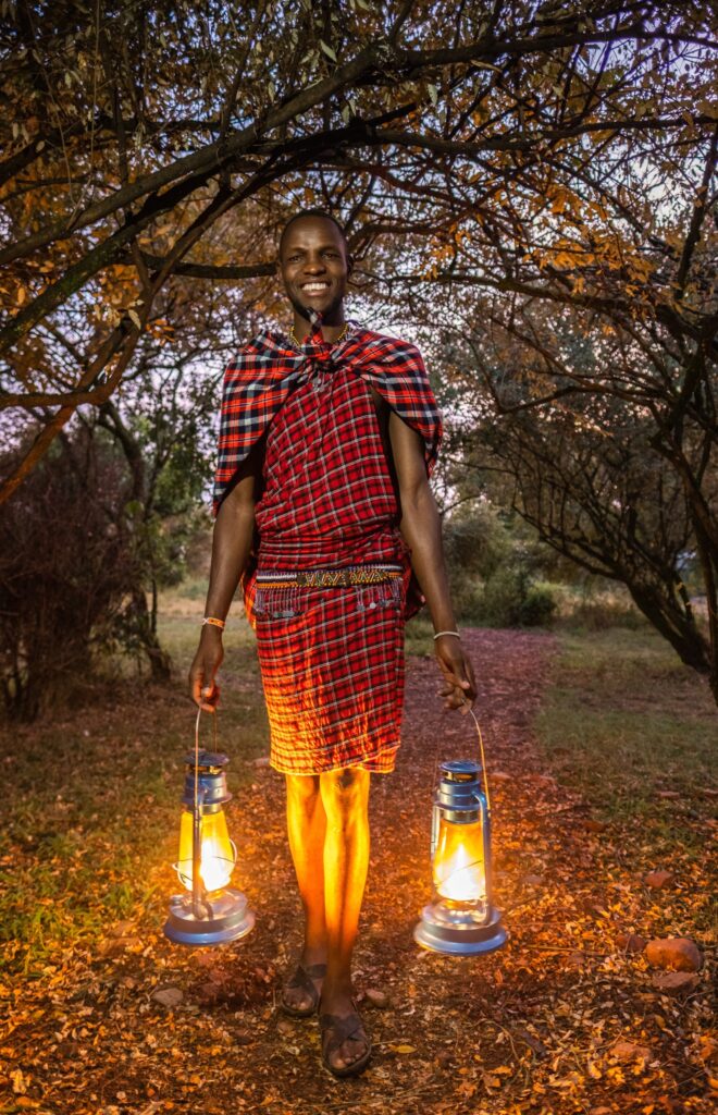 A Maasai Warrior holding 2 lamps at Enkakenya