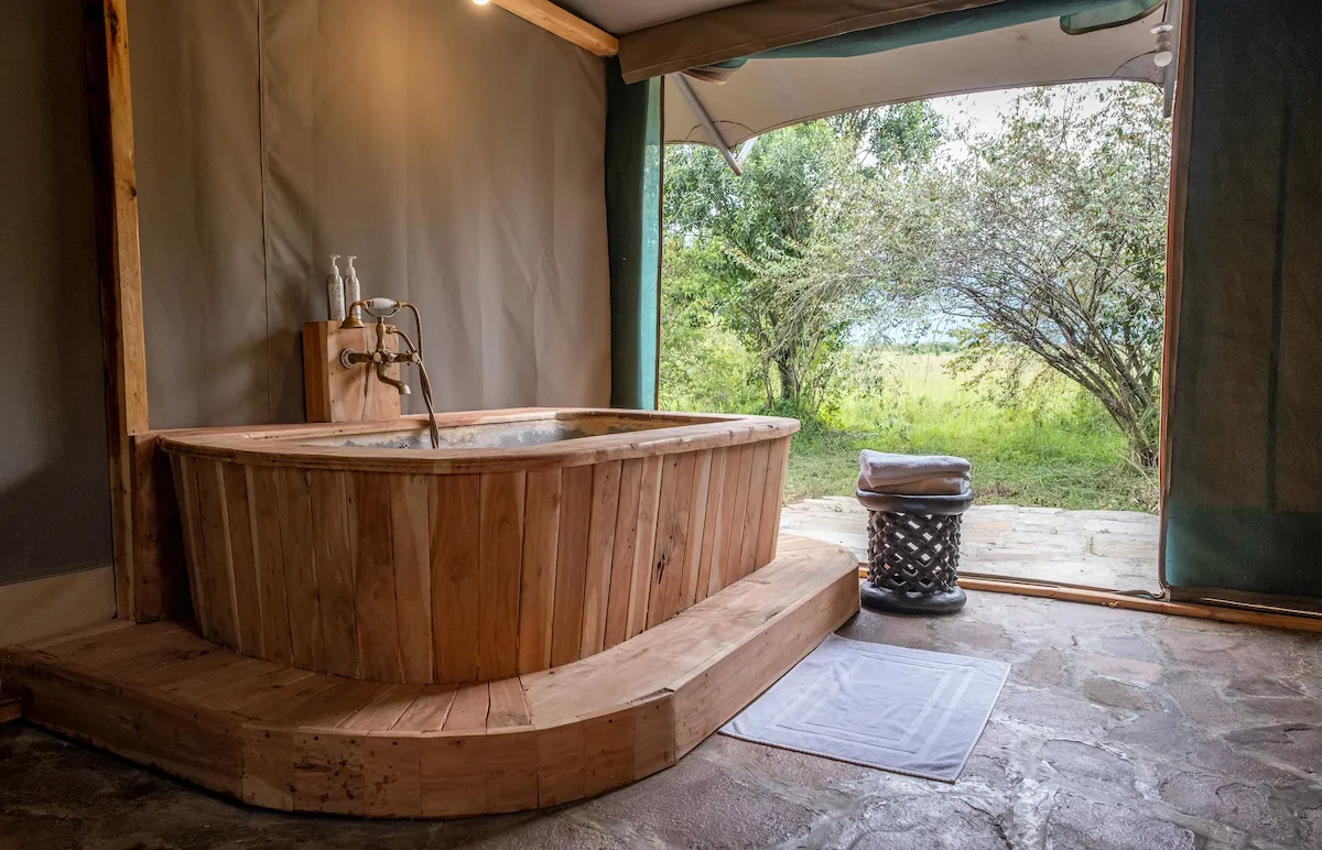 Hand-crafted wooden soaking tub opening to the Mara bush